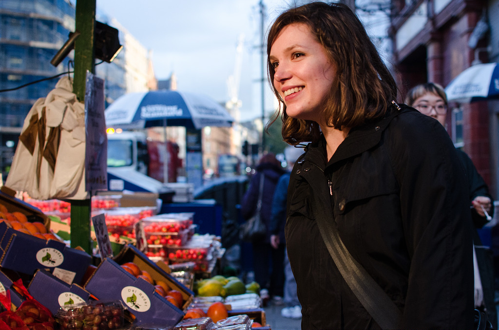 A lady shopping at a fruit and veg stall in a market