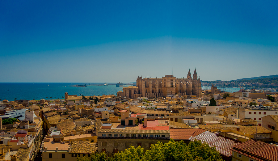 PALMA DE MALLORCA, SPAIN - AUGUST 18 2017: Gorgeous view of rooftops of the city of Palma de Mallorca with the Cathedral of Santa Maria in the horizont in a beautiful blue sunny day in Palma de Mallorca, Spain.