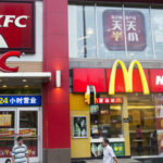 Pedestrians walk past a KFC restaurant, operated by Yum! Brands Inc., left, and a McDonald's Corp. restaurant in the Luohu district of Shenzhen, China, on Monday, Aug. 4, 2014. Yum, owner of KFC and Pizza Hut, said its China team is trying to regain customers after a supply chain scare has recently hurt results. Photographer: Brent Lewin/Bloomberg via Getty Images