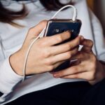 Teenager listens to music on their smartphone