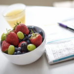 Bowl of fruit alongside a newspaper