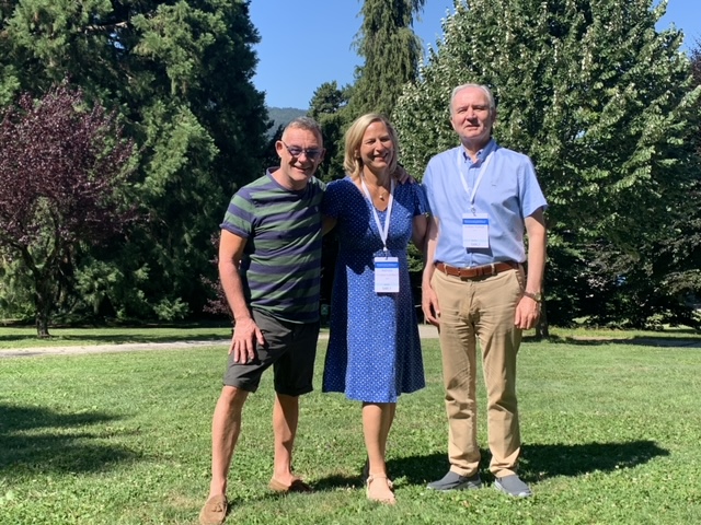 Three attendees stand together in the venue garden