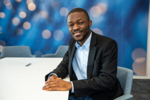 Businessman smiling at camera in a conference room with bokeh background.