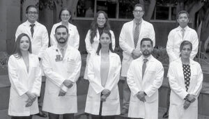 A group of healthcare professionals in white lab coats posing for a photo.