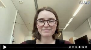 A woman with glasses and a slight smile appears on a video call in an office setting. The EASO logo is visible in the top right corner.